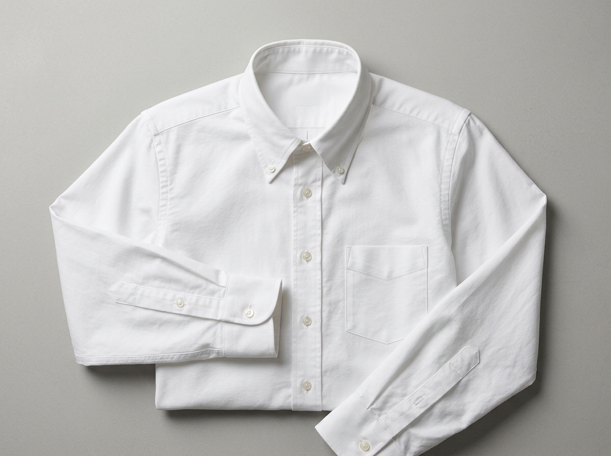 Flat-lay product photograph of a plain white Oxford cotton shirt with no collar label or hang tag visible